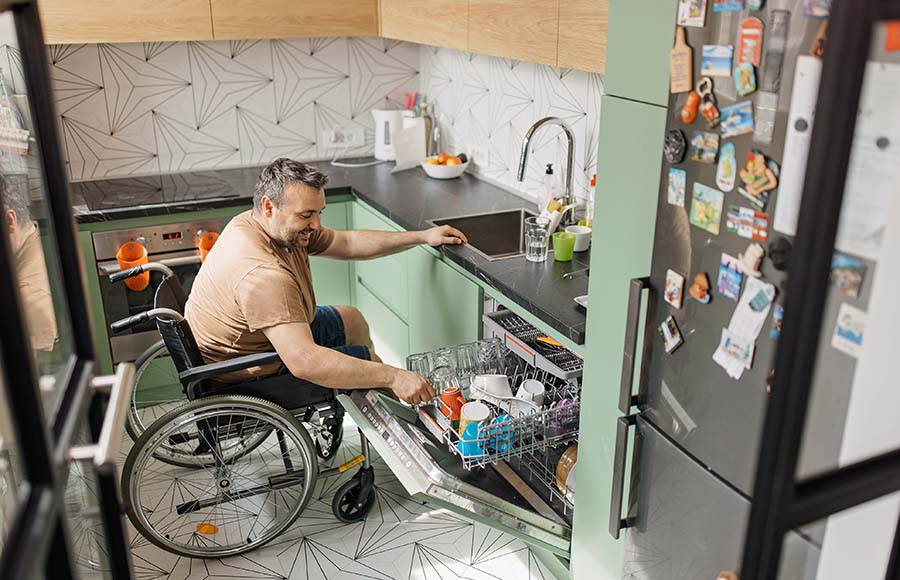 Una casa accesible fomenta el movimiento y la independencia Descripción: persona en silla de ruedas en una cocina